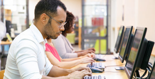 Digital Academic Records: A Credential Evaluator’s Perspective Lead Image: Photo of young professionals working on a computer